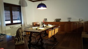 A dining area with a wooden table set for four, a vintage typewriter, and a pendant light above. - Large apartment big lounge fireplace two terraces (Venezia)