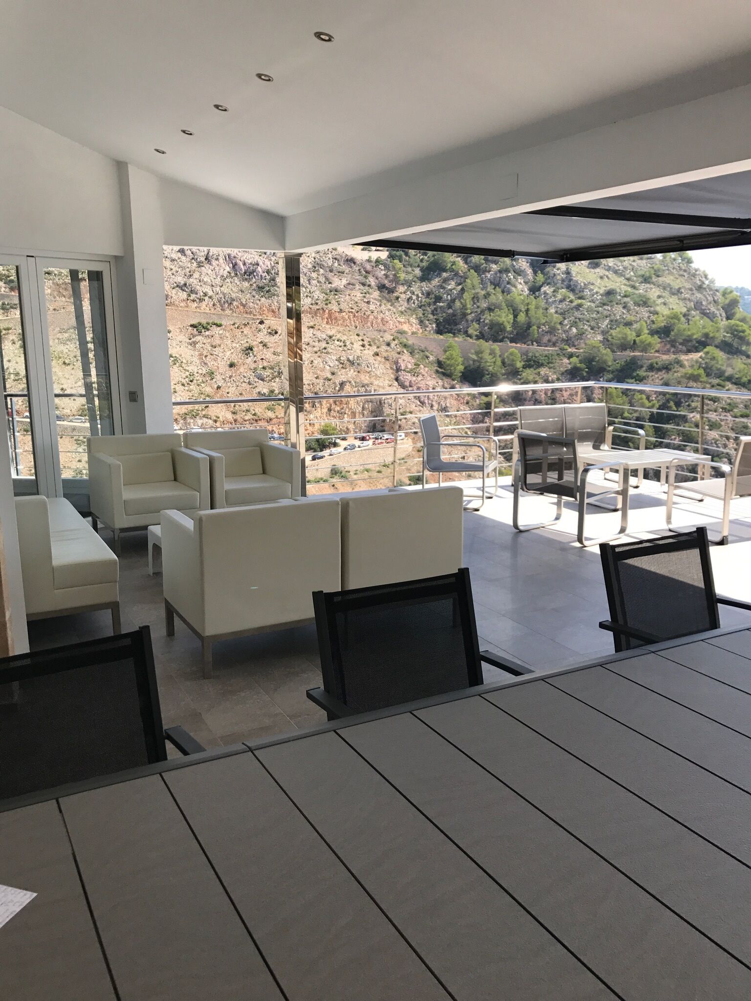 A modern outdoor seating area with a view of a mountainous landscape.