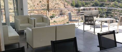 A modern outdoor seating area with a view of a mountainous landscape.