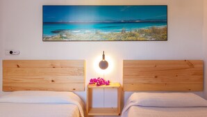 Una camera da letto con una testiera in legno, un comodino con una lampada e un quadro raffigurante una spiaggia.