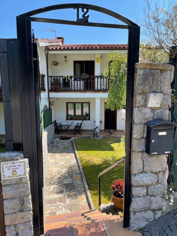 Un bâtiment à deux étages doté d’un balcon, d’un chemin de pierre menant à l’entrée et d’une enseigne indiquant un service de garde d’animaux.