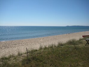 A beach with a clear sky, a sandy shore, and a small red boat. - Two lovely guest cottages in Juleboda too close to stunning beach (Degeberga)