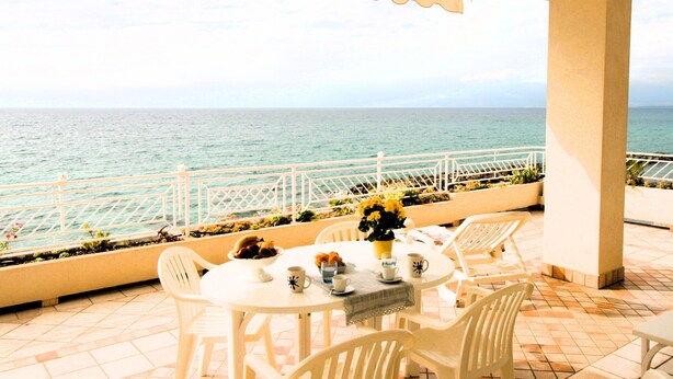 A terrace with a table set for dining, overlooking the sea. - Villa Laura PT - directly by the sea (Pizzo)