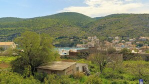 A coastal town with a hillside backdrop, featuring a mix of residential buildings and open spaces. - Mondo Room 1 - One Bedroom Apartment, Sleeps 2 (Mokosica)