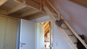 A wooden staircase with a heart-shaped decoration, a white door, and a wooden wardrobe. - family friendly and for nature lovers (Weinheim)
