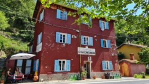 A red building with blue shutters and a sign reading "CASA CANTONIERA". - Historic house lovingly furnished in original vintage style (Cesio)