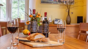 Une table à manger avec une miche de pain, deux bouteilles de vin et des verres à vin.