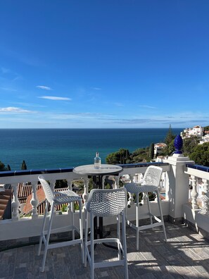 Enjoy a serene sea view from this outdoor space with a table for two and a bottle at the ready.