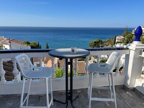 Enjoy the serene sea views from this balcony, featuring a comfortable seating area with two chairs and a table.