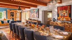 Comedor con una mesa de madera lista para una comida, rodeado de sillas.