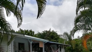 A house with a pool, surrounded by lush greenery and palm trees. - bungalow the box lace (Le diamant)