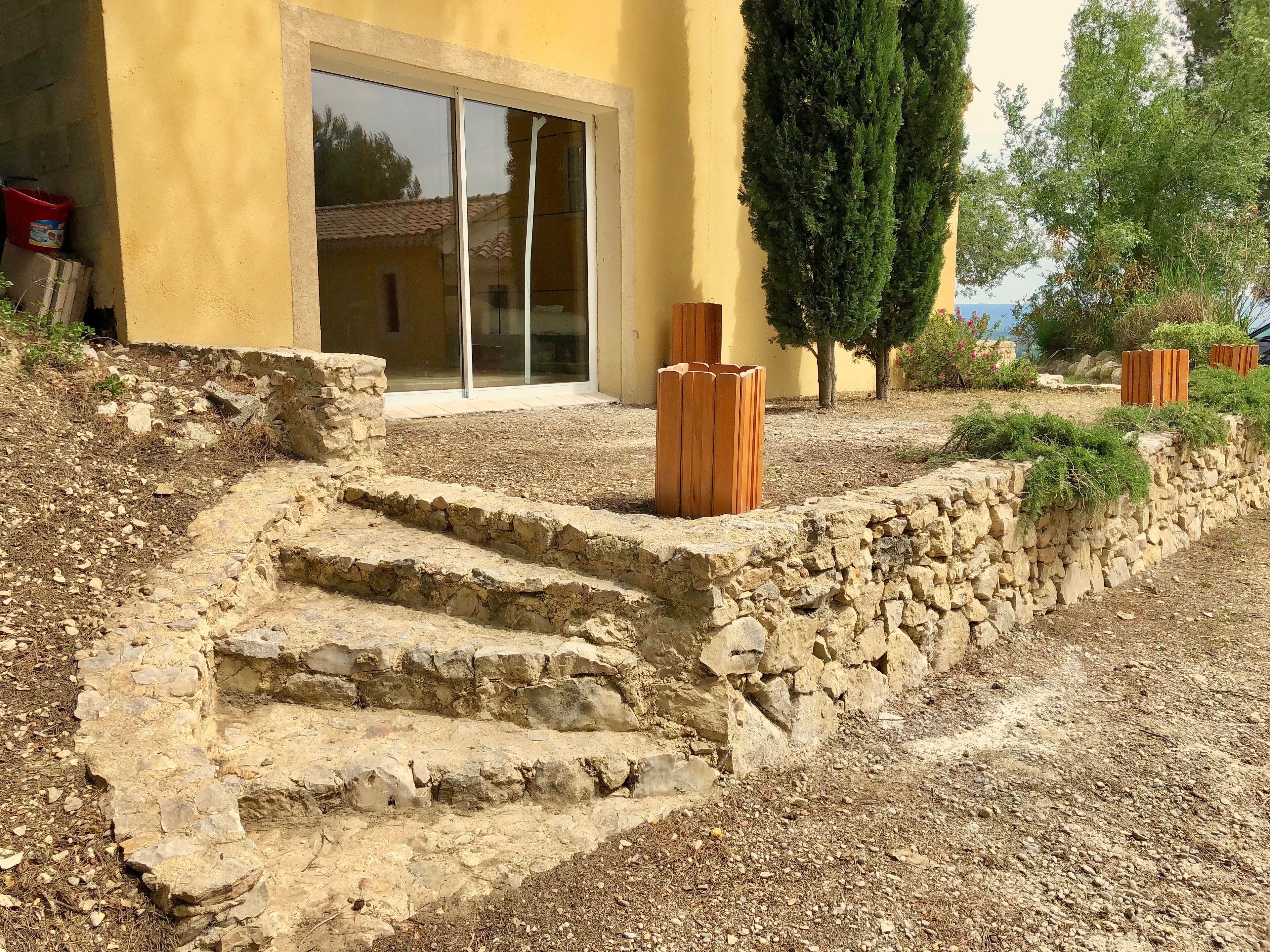 A stone staircase leading to a yellow building with a glass door.