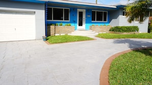 Een tweelaags huis met garage, voortuin en een verzorgd gazon.