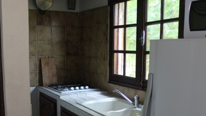 Eine Küche mit Fenster, Herd und Kühlschrank.