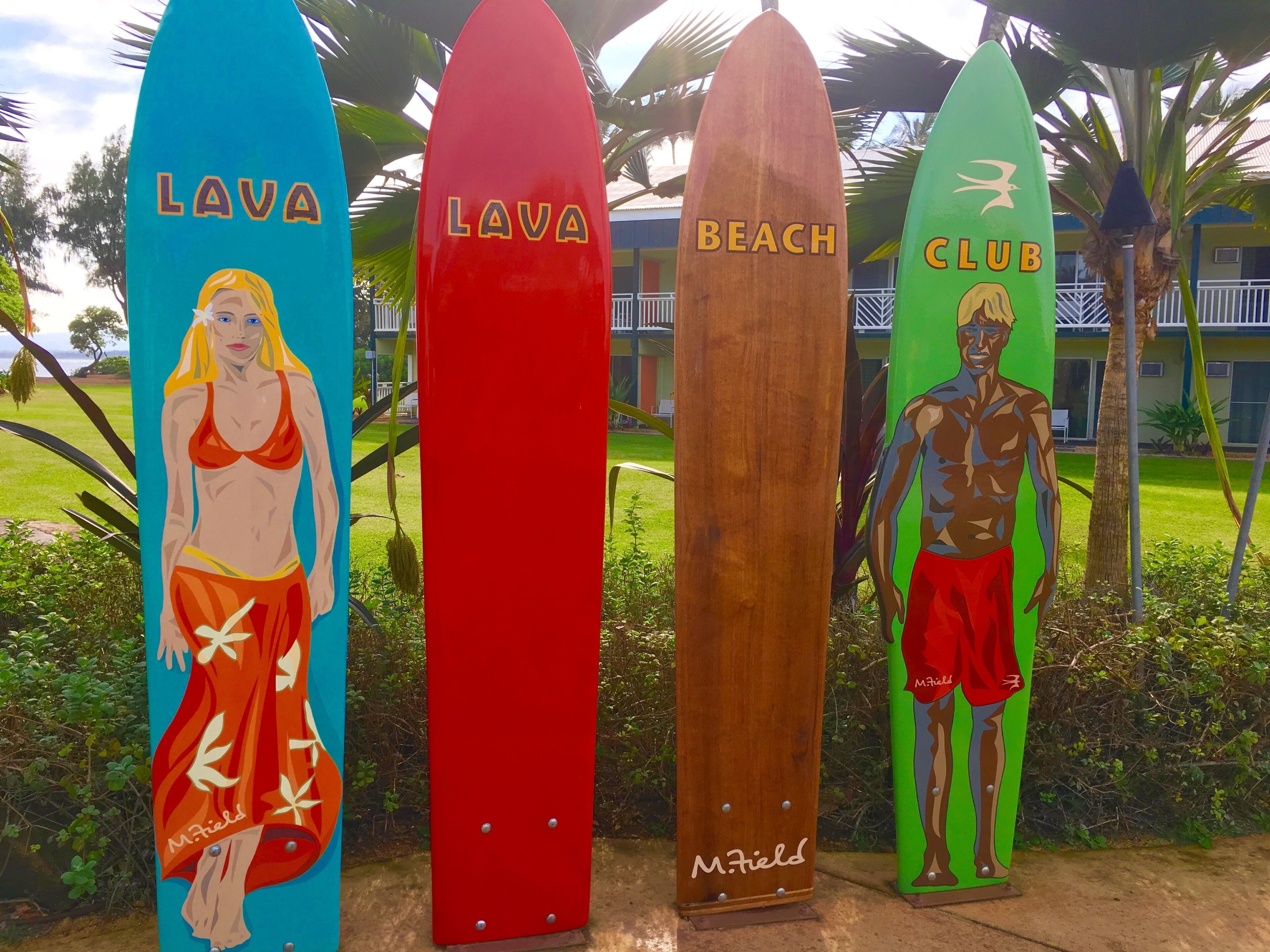 Four surfboards with names: Lava, Beach, Club, and M. Fields.