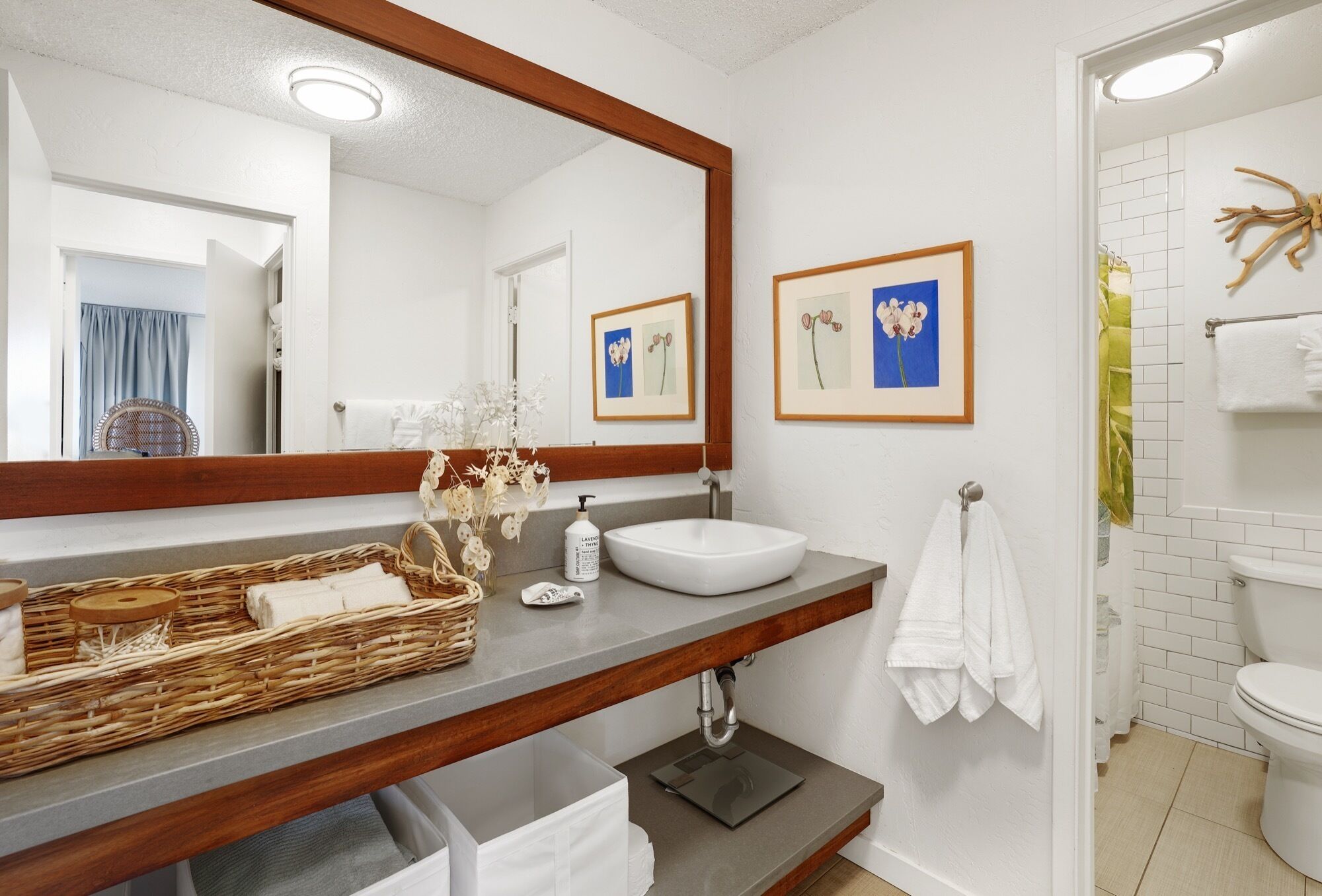 A bathroom with a large mirror, white sink, and a towel rack.