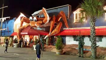 Un gran crustáceo, mascota, frente a un edificio con techo rojo y un letrero que dice 'Giant Club'.