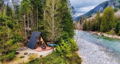 Cozy mountain A-Frame cabin on river w hottub & views. Minutes from hikes & ski!