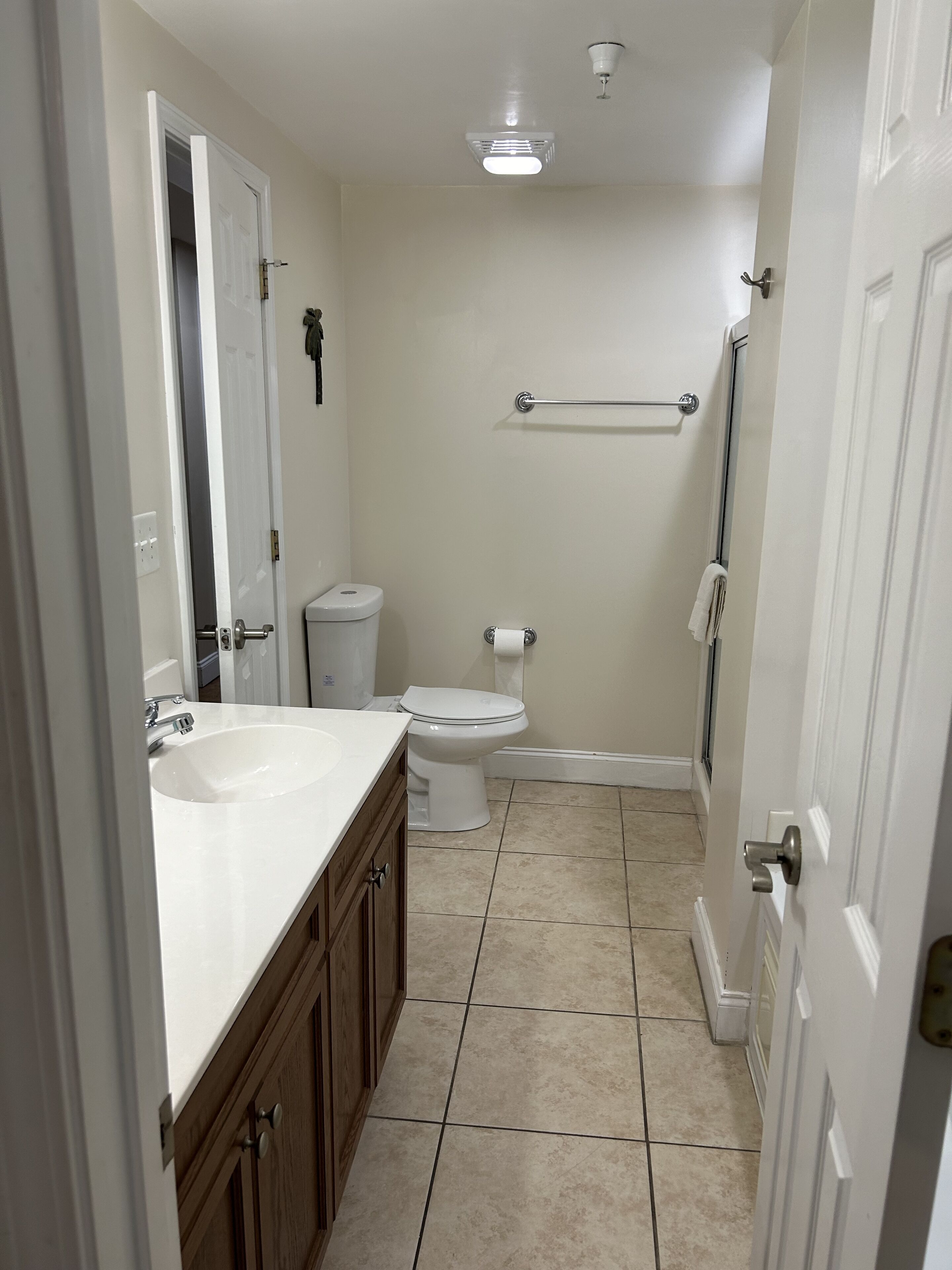 A bathroom with a white sink, toilet, and shower area.
