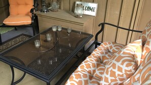 Un'accogliente area salotto con un tavolino in vetro, una poltrona imbottita e un cartello con la scritta 'WELCOME'.