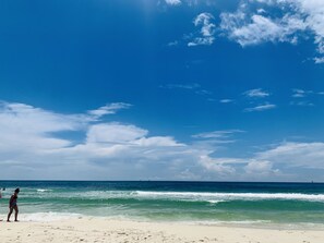 Een strand met een heldere lucht en oceaan.