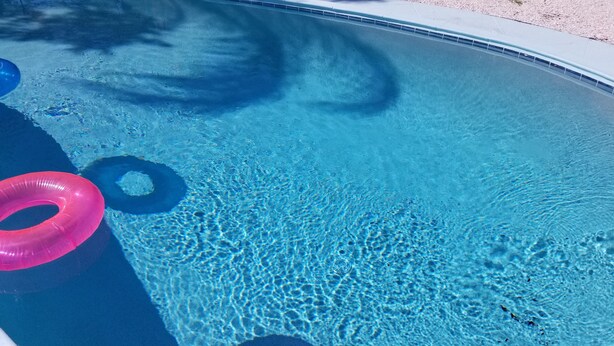 A clear blue pool with two visible inflatable rings. - Centrally located Oasis  (Sarasota)