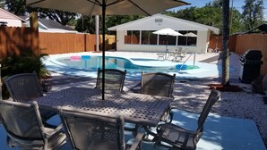 A backyard with a pool, outdoor furniture, and a covered patio area. - Centrally located Oasis  (Sarasota)