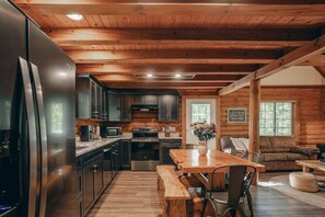 Ein Ferienhaus-Innenraum mit Küche, Essbereich und Wohnzimmer.