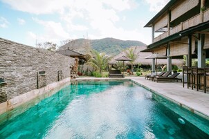 Una piscina al aire libre, sillones reclinables de piscina