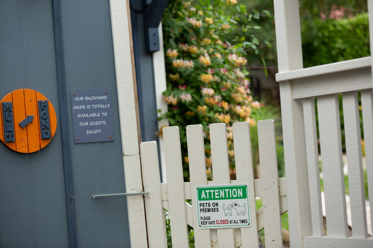 A gated entrance with a sign indicating the backyard is available to guests.