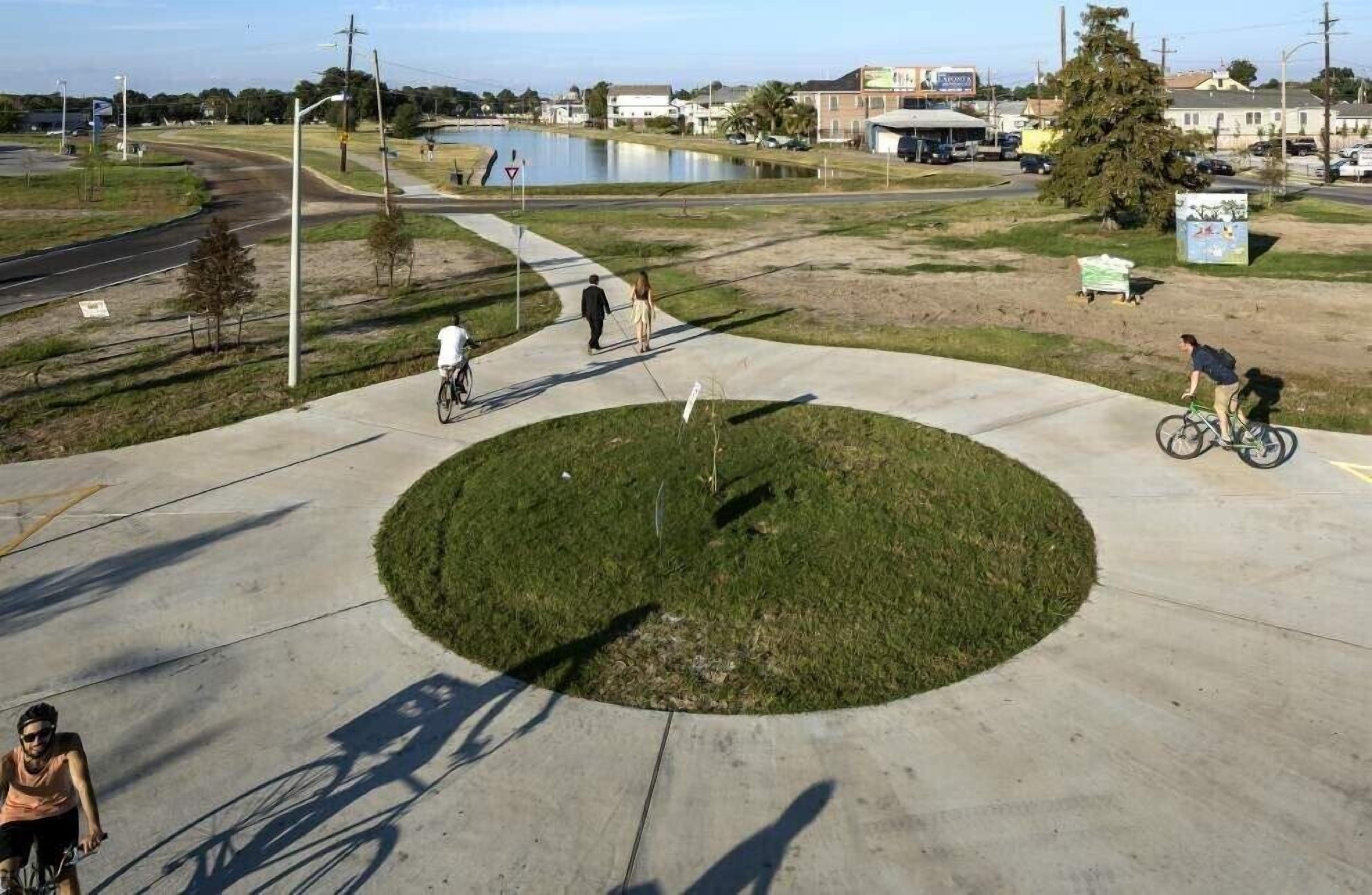 Un área circular de concreto con césped en el centro, rodeada por un sendero de concreto.