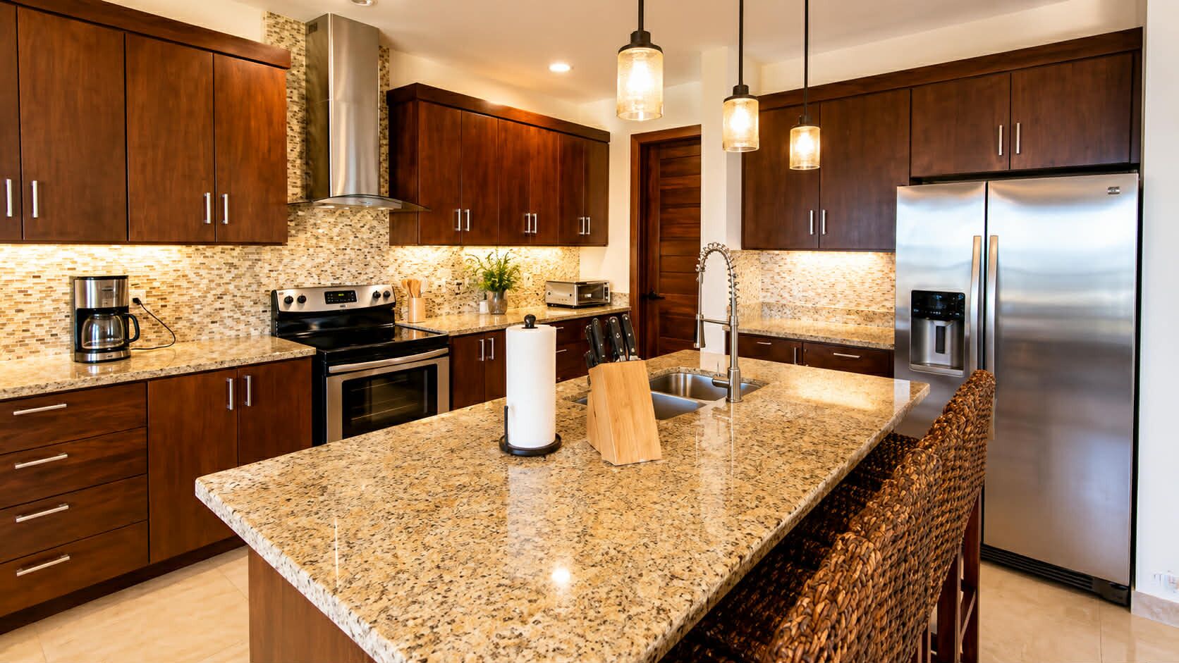 A modern kitchen with granite countertops, stainless steel appliances, and wooden cabinets.