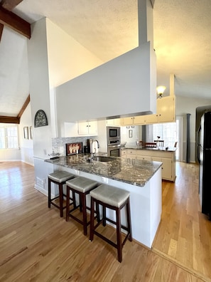 A spacious kitchen with a large island, wooden bar stools, and modern appliances. - Hiking, Mountains, Golf, Pools, Lake Waterslide Resort Mountain Home (Big Canoe)