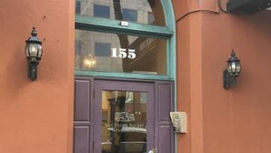 A building with a purple door, number 155, and two wall-mounted lamps. - 308-Immaculate Studio San Pedro Sq. San Jose! (San Jose)