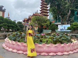 A person standing in front of a traditional pagoda with a lotus pond. - Anh Quan Hotel (Quy Nhon Nam)