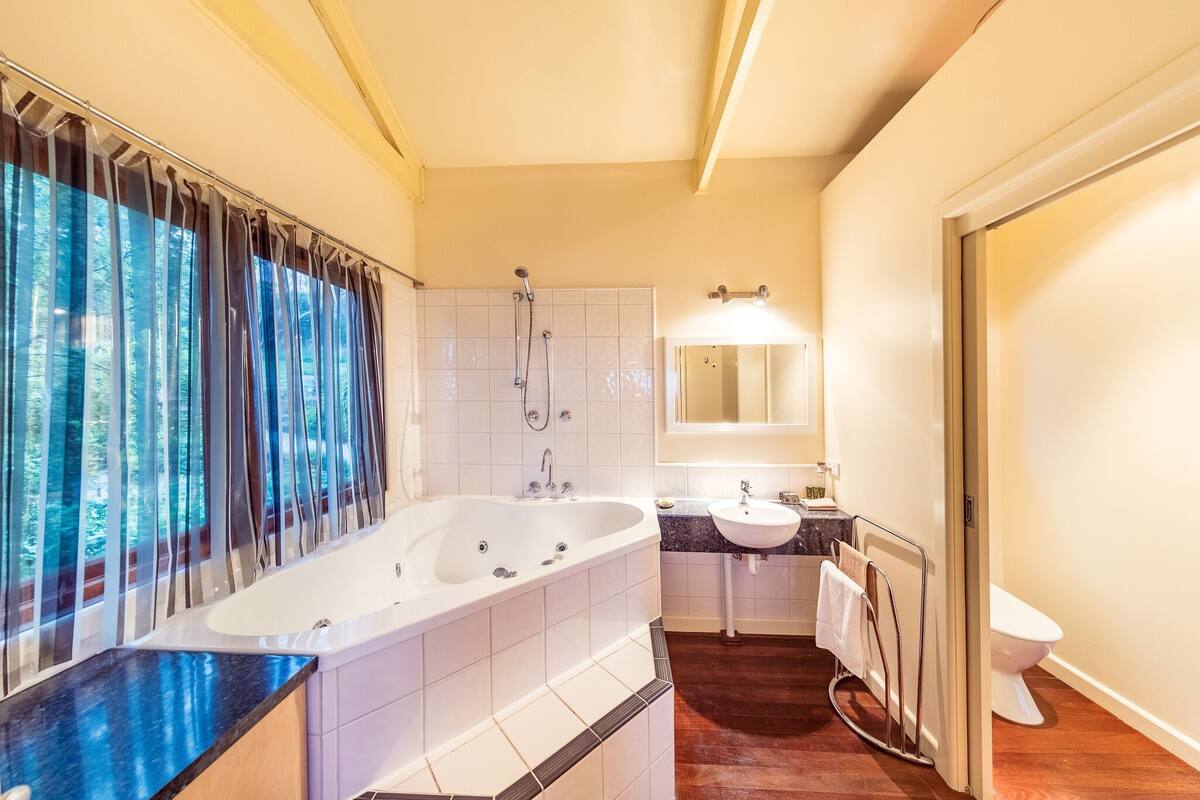 A modern bathroom with a bathtub, sink, and toilet.