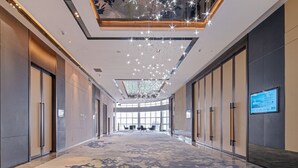 A spacious hotel corridor with a high ceiling, modern lighting, and a large screen displaying information. - Grand Skylight International Hotel Haoyue Shenzhen (Shenzhen)