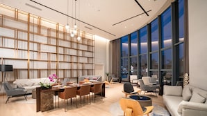 A modern living room with a sofa, dining table, chairs, and a large window with city views. - Grand Skylight International Hotel Haoyue Shenzhen (Shenzhen)