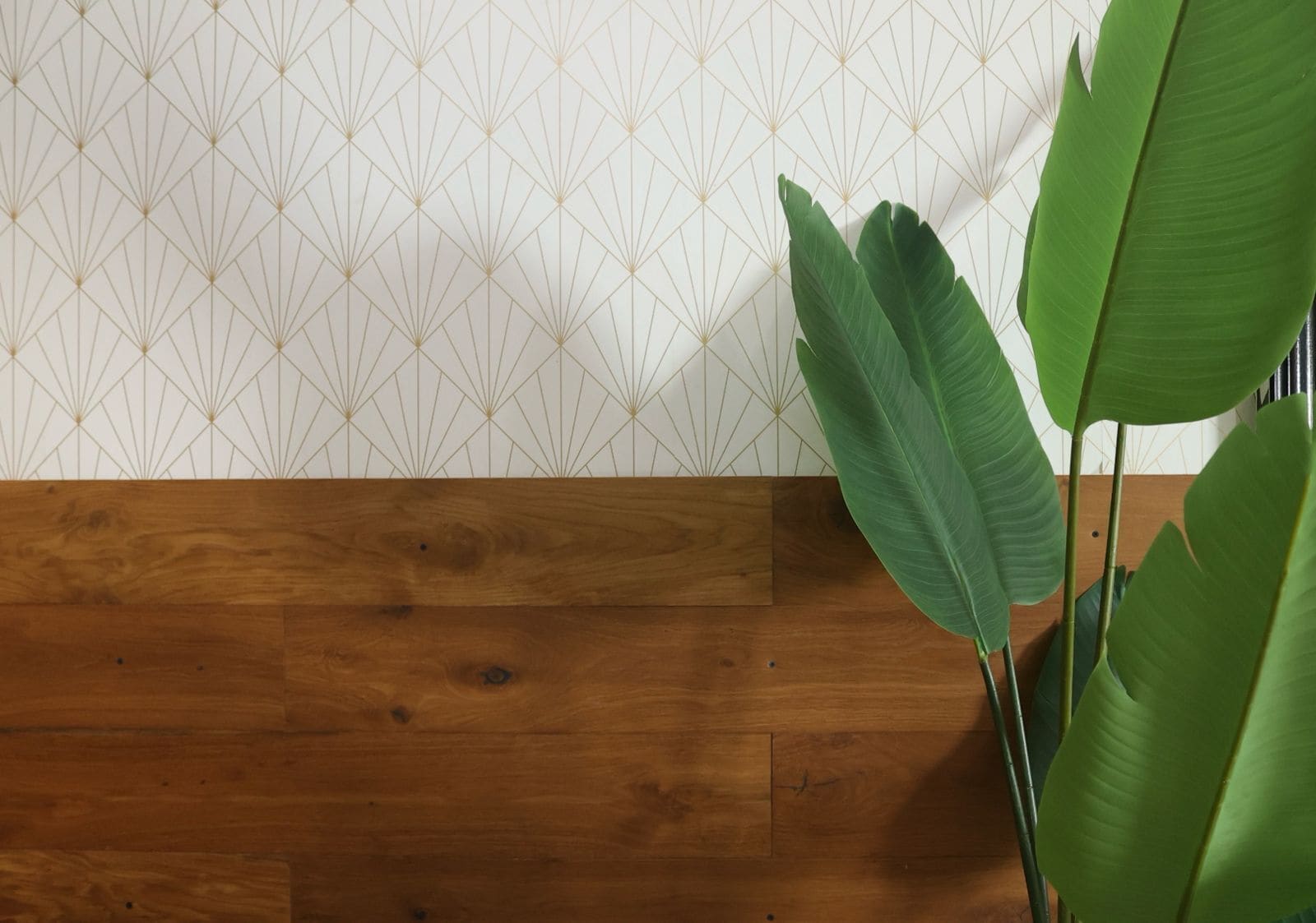 Un suelo de madera junto a una pared con un estampado geométrico.