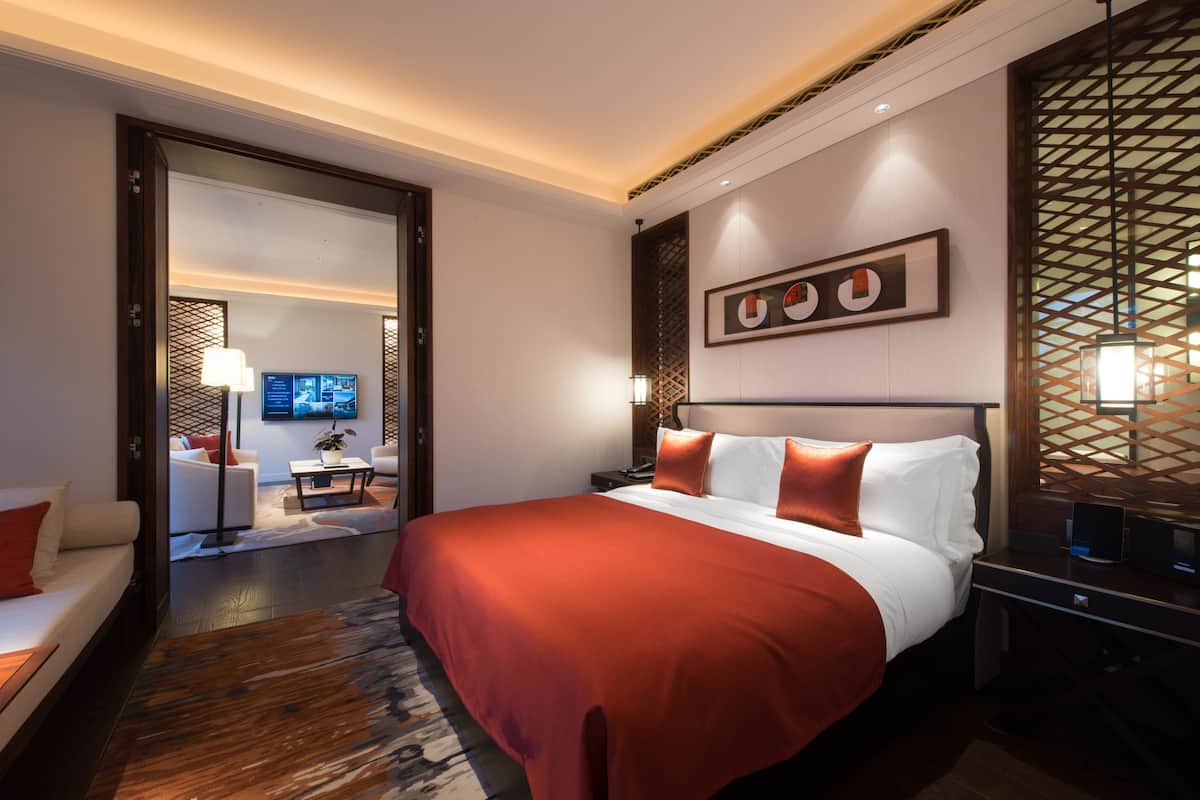 Une chambre d’hôtel moderne dotée d’un grand lit, d’un bureau et d’un coin salon.