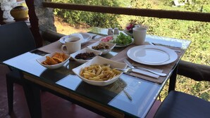 A table set outdoors with various dishes, a cup, and a plate. - Lei Thar Gone Guest House (Yenangyaung)