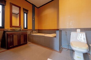 A modern bathroom with a glass bowl sink, a bathtub, and a toilet. - Nai Harn Grand Villa (Rawai)