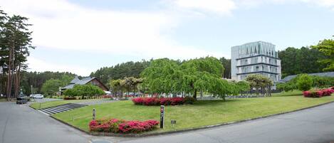 A modern building with a unique architectural design, surrounded by well-maintained lawns and trees.