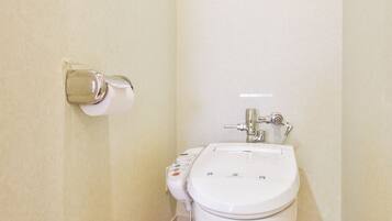 A bathroom with a toilet, a bidet, and a sink.