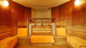 Un sauna con paredes de madera, bancos e iluminación empotrada.