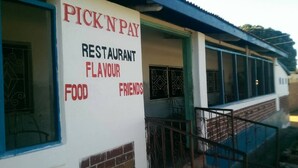 Un restaurante llamado "Pick 'n Pay" con un cartel que anuncia "Restaurante, Sabor, Comida, Amigos".