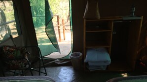 Una habitación con dos camas, una silla, una mesita y un armario.