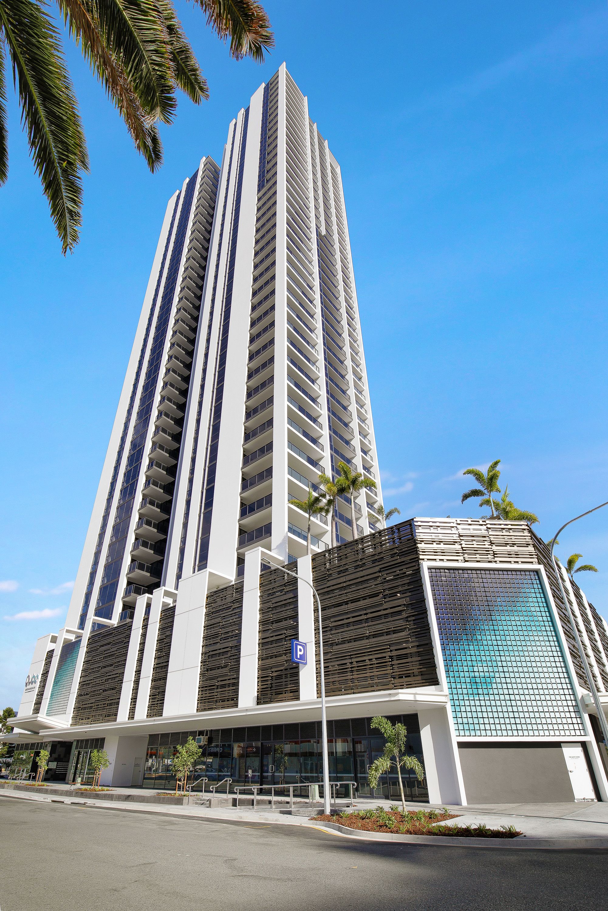 Un edificio alto y moderno con una entrada destacada y un amplio fachada de vidrio.
