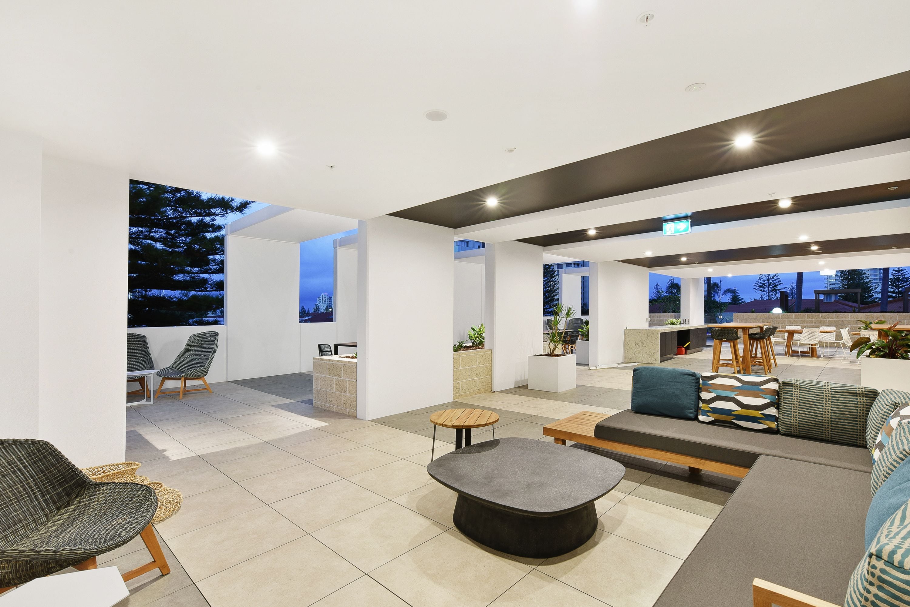 A modern lounge area with seating, a coffee table, and a view of the outdoors.