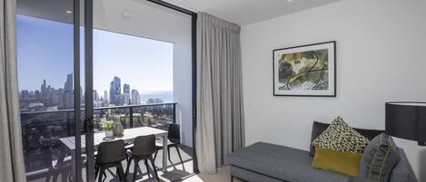 A modern living room with a balcony, a sofa, a table, and chairs.